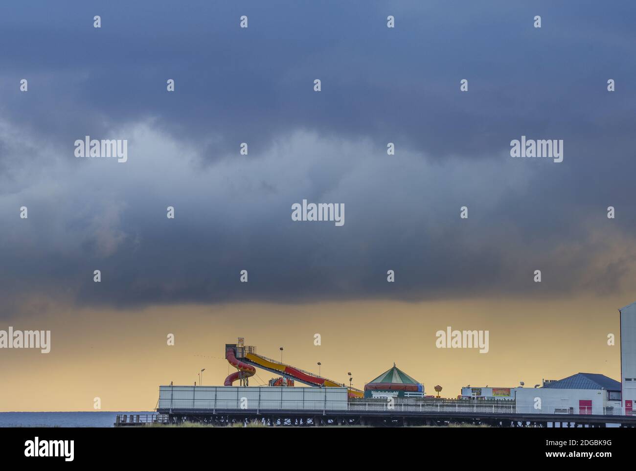 Nuages sombres et pluie lointaine qui encadrent Britannia Pier dans un après-midi hivernal de mauvaise humeur - Great Yarmouth, Norfolk (Royaume-Uni) Banque D'Images