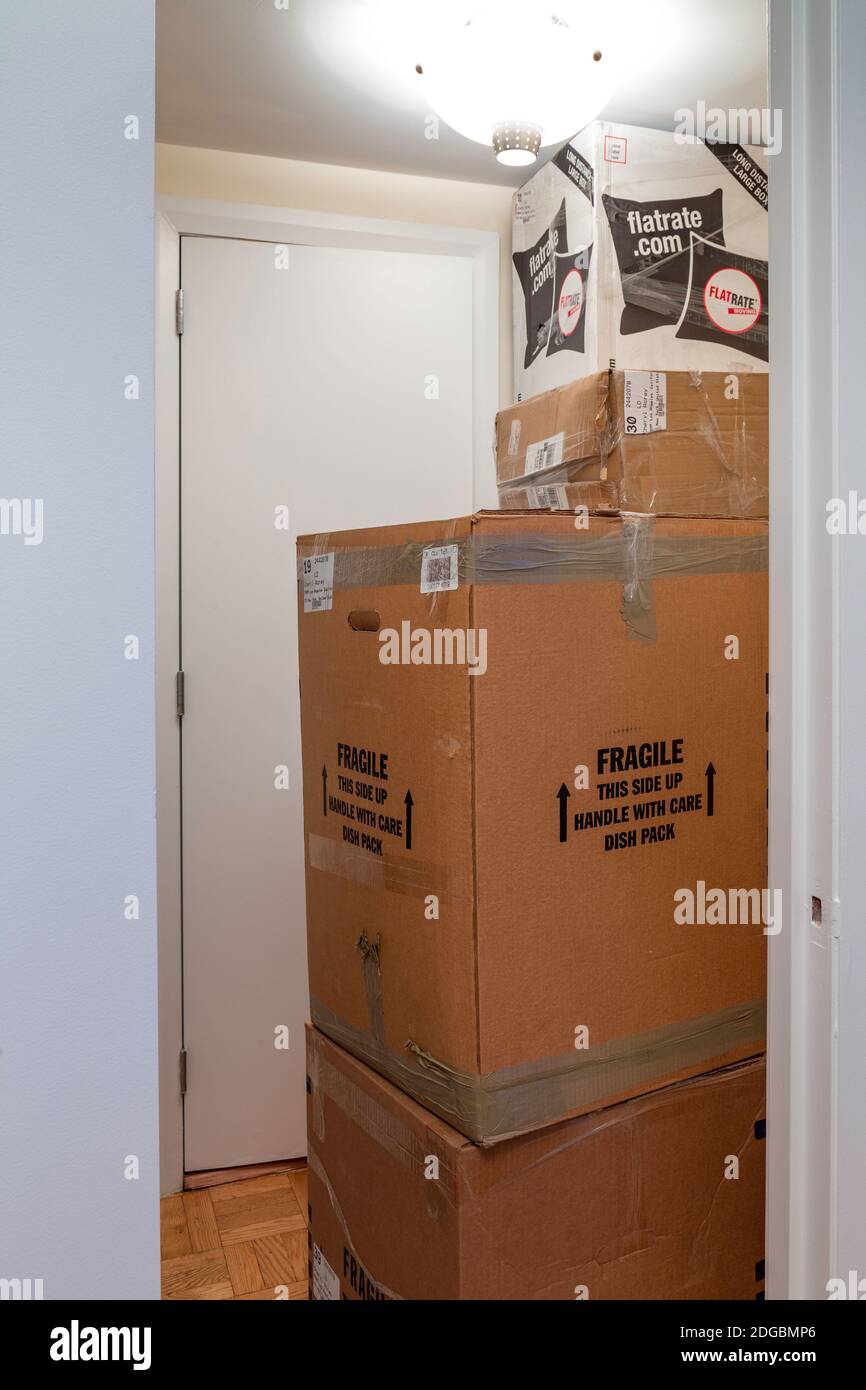 Des piles de boîtes mobiles en carton submergent un petit appartement de New York City, États-Unis Banque D'Images