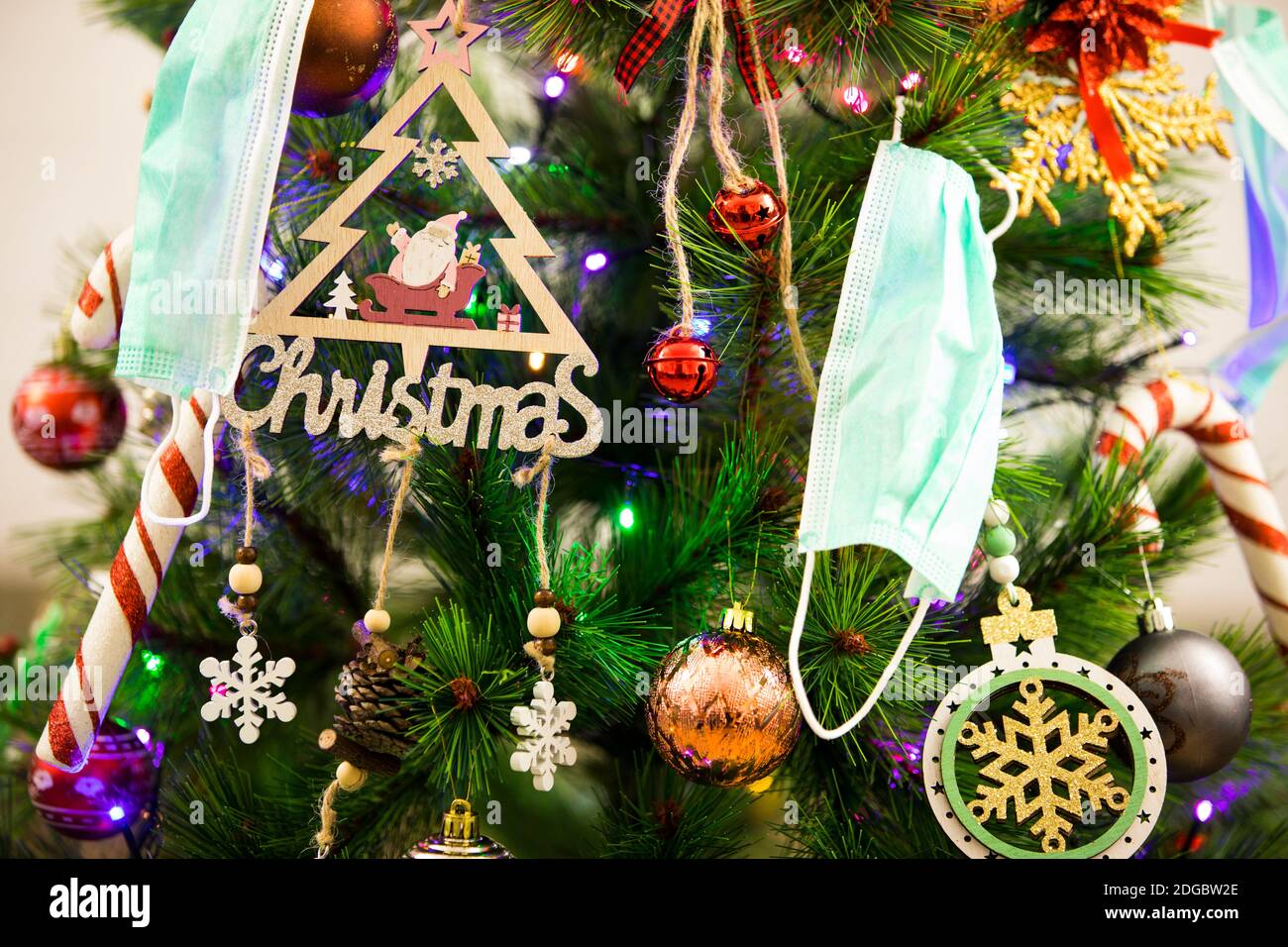 Décorations de Noël et un masque de visage accroché à un Noël arbre Banque D'Images