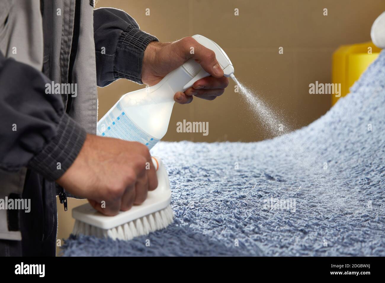 Homme utilisant du spray pour enlever la tache du tapis dans le tapis  service de nettoyage Photo Stock - Alamy