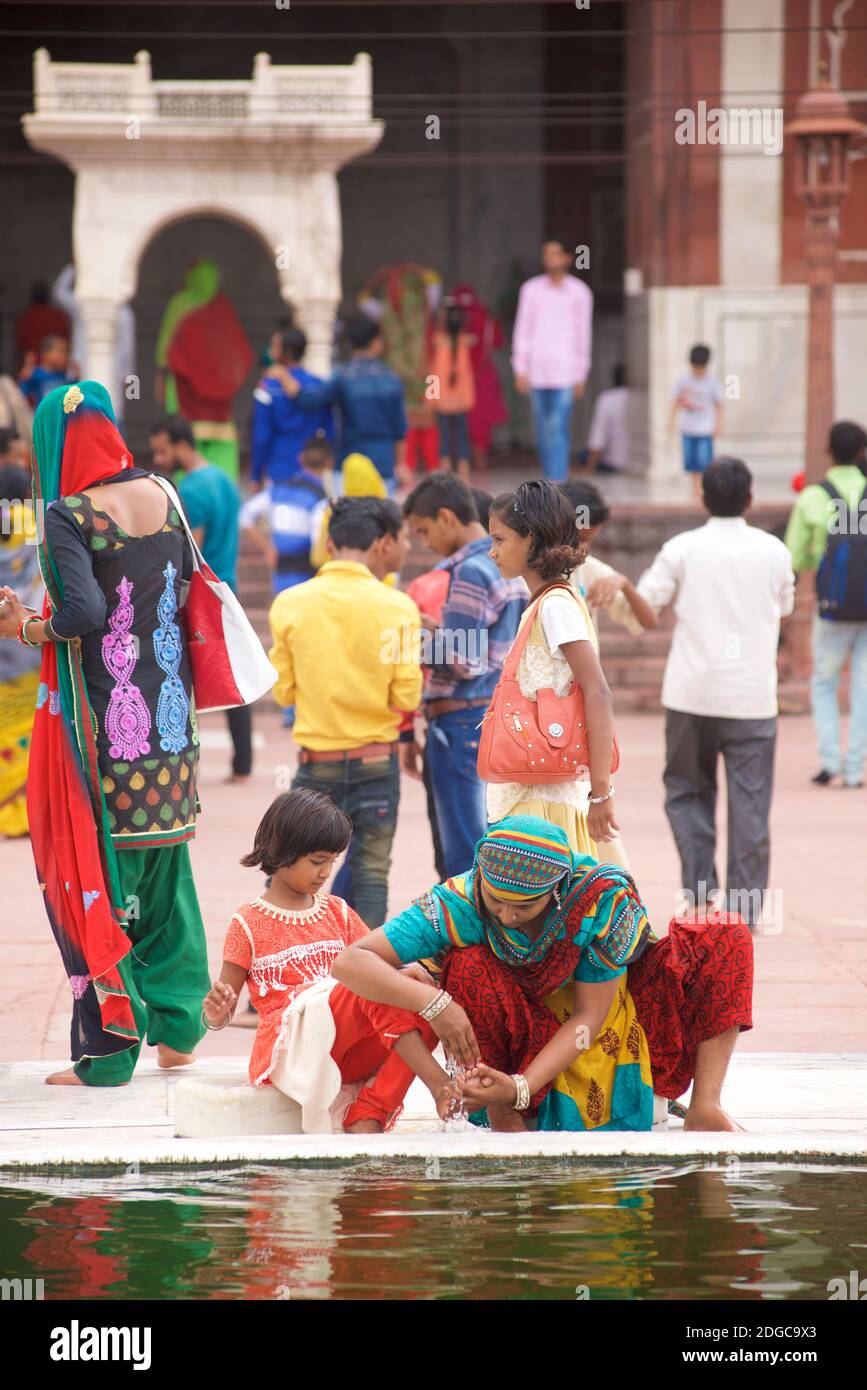 Des personnes se sont rassemblées près de la fontaine dans la cour centrale de la Jama Masjid, une mosquée de style moghol du XVIIe siècle, dans la vieille ville de Delhi, en Inde Banque D'Images
