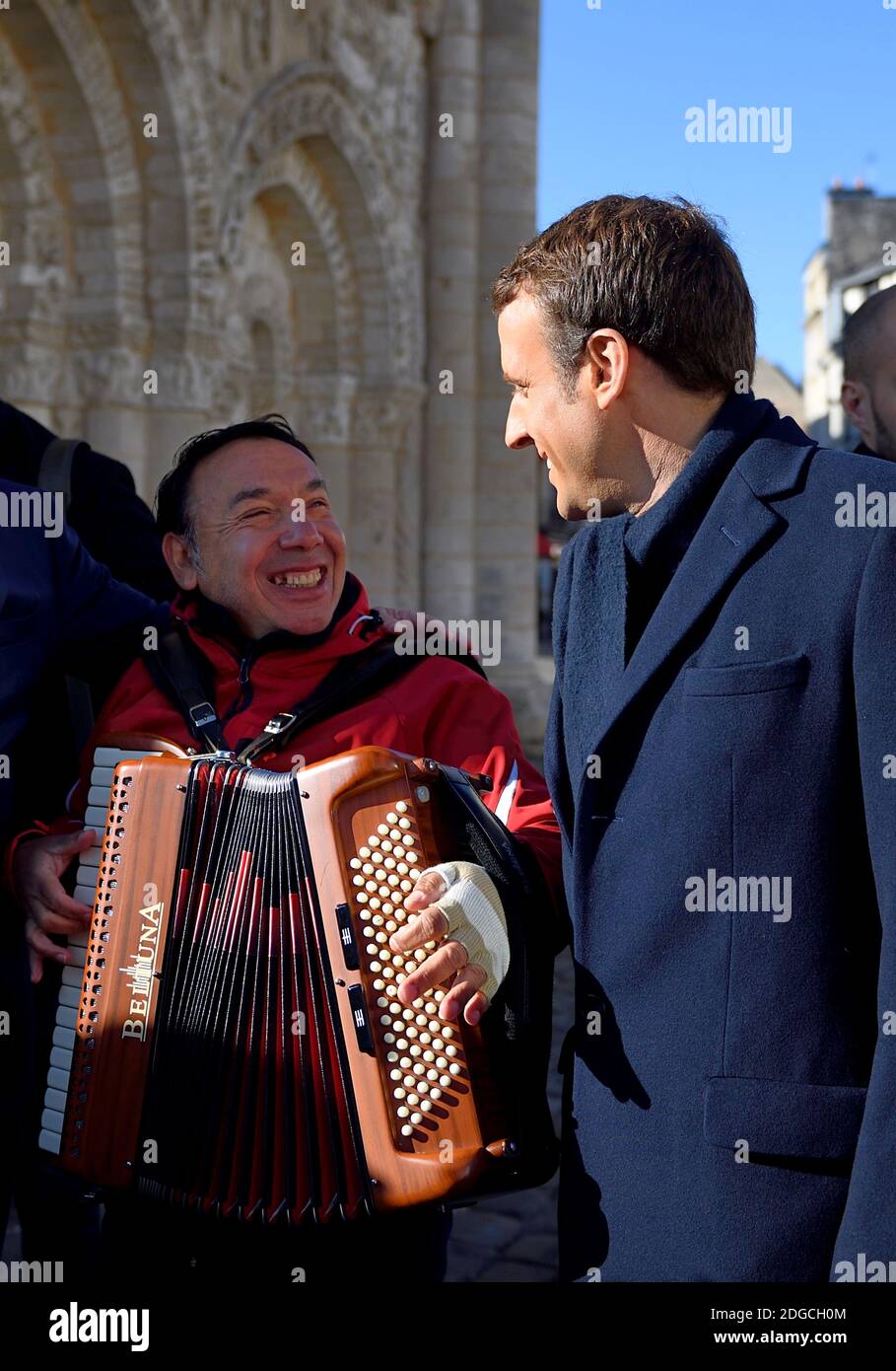 En marche ! Le candidat aux élections présidentielles françaises de 2017,  Emmanuel Macron (R), écoute un joueur d'accordéon tout en faisant campagne  à Poitiers, dans le centre de la France, le 29