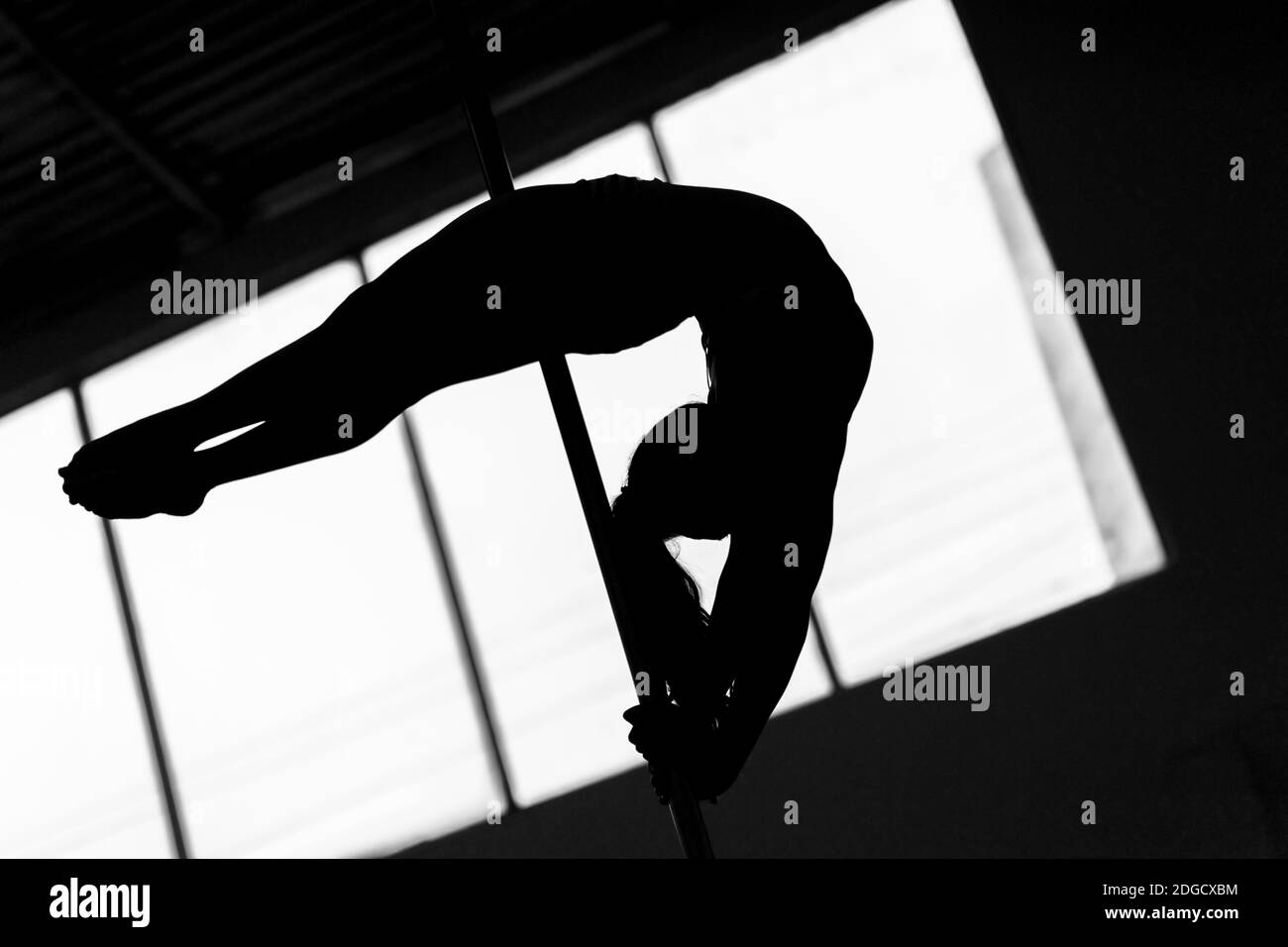 Une jeune danseuse colombienne de pole diabolise ses compétences en gymnastique lors d'une session d'entraînement de danse de pôle dans une salle de gym à Bogotá, en Colombie. Banque D'Images