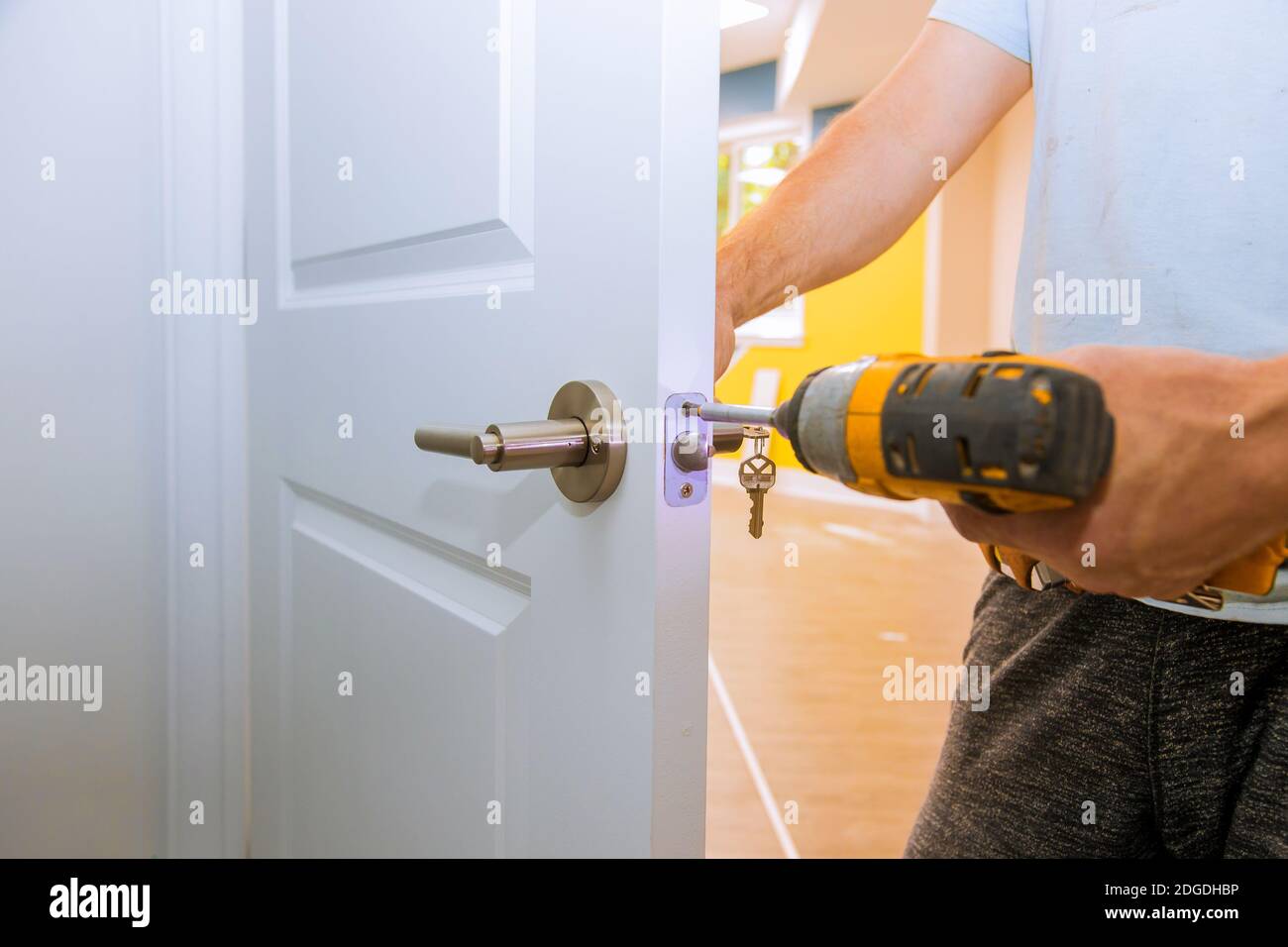 Menuisier à l'installation de serrure avec porte en bois Banque D'Images