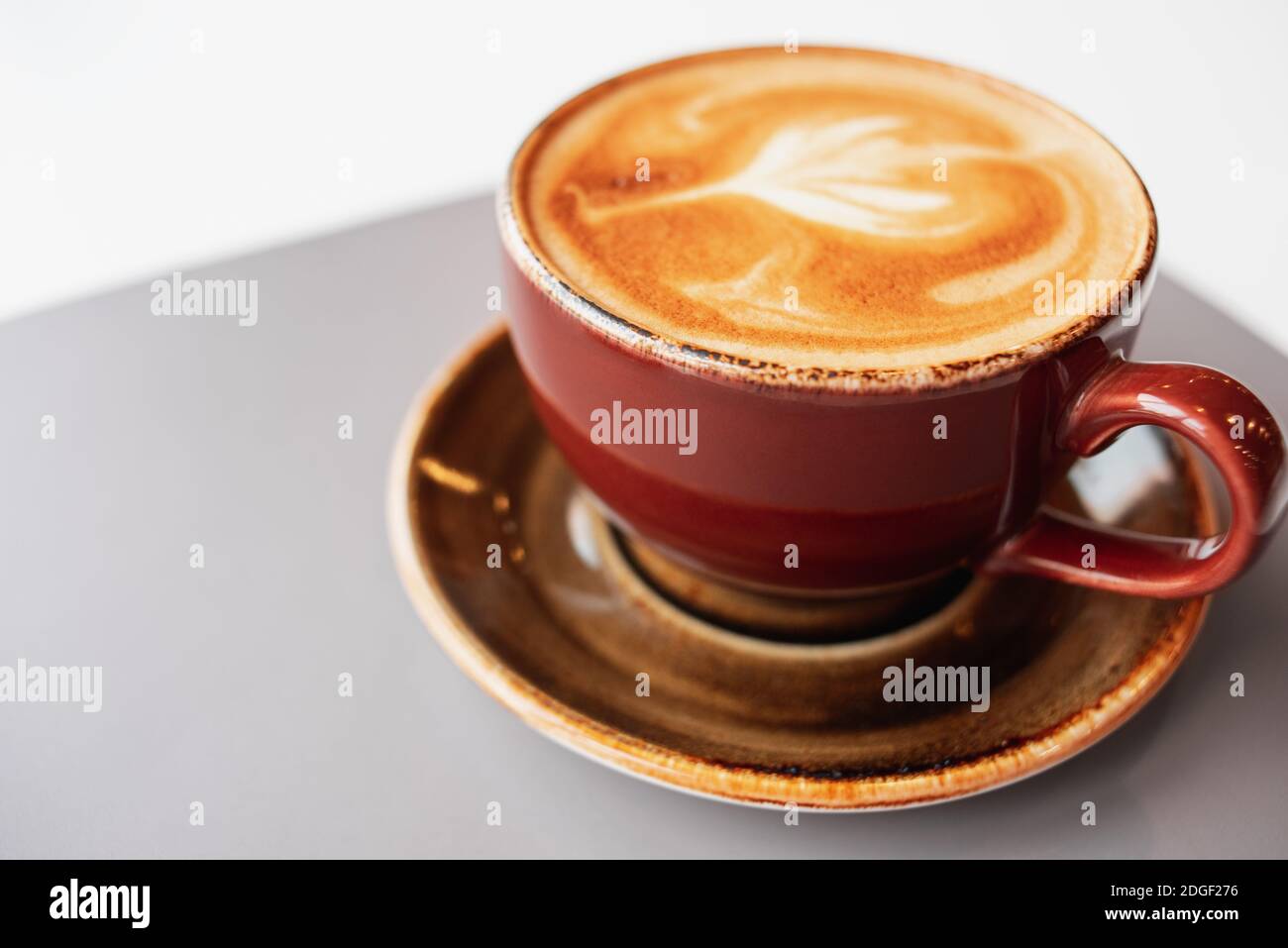 Café du matin dans une tasse en céramique avec mousse. Cappuccino frais aromatique. Pause café dans un café. Banque D'Images