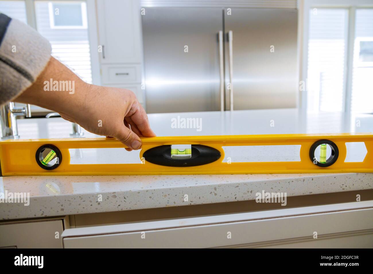 Un travailleur vérifie la mise à niveau des comptoirs en granit dans un maison cuisine remodélisation Banque D'Images