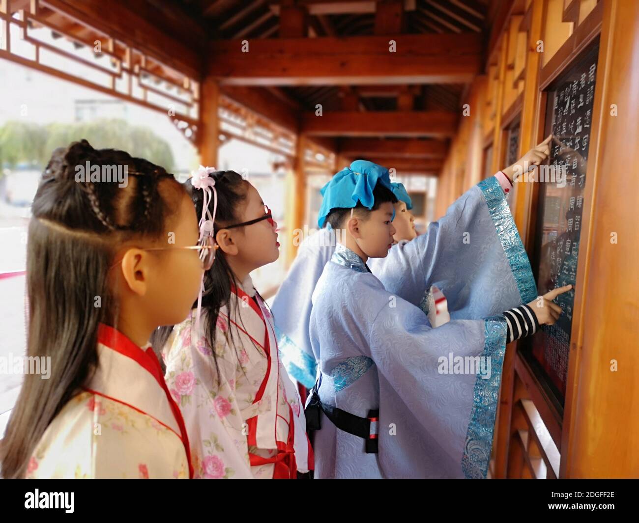 Les élèves de l'école primaire vêtus de Hanfu, un costume traditionnel chinois, écrivent la calligraphie et apprennent la culture traditionnelle dans la ville de Jilin, au nord-est Banque D'Images