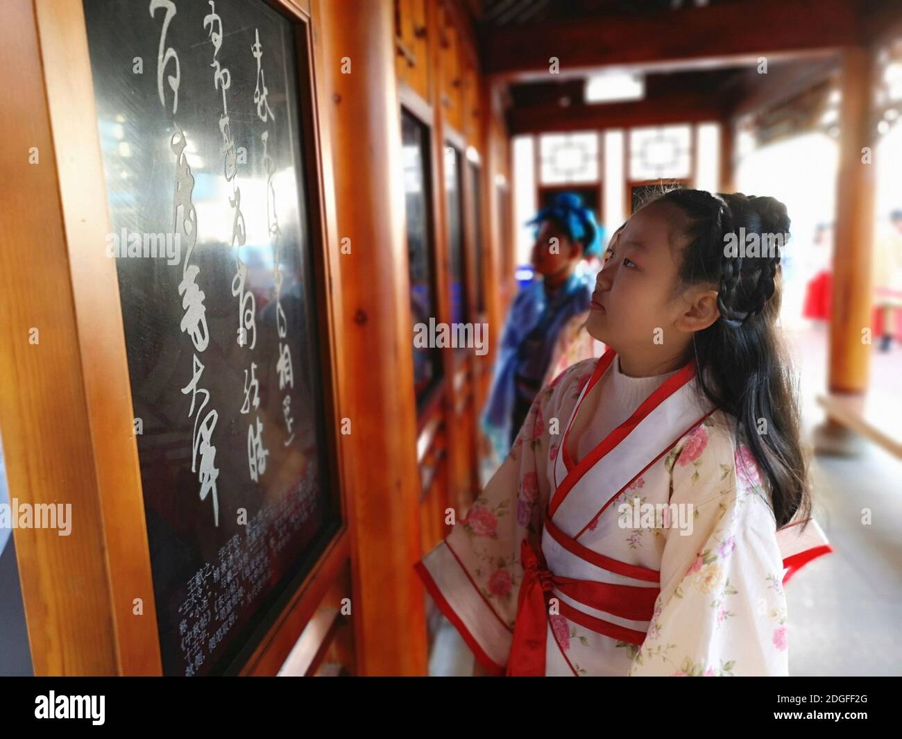 Les élèves de l'école primaire vêtus de Hanfu, un costume traditionnel chinois, écrivent la calligraphie et apprennent la culture traditionnelle dans la ville de Jilin, au nord-est Banque D'Images