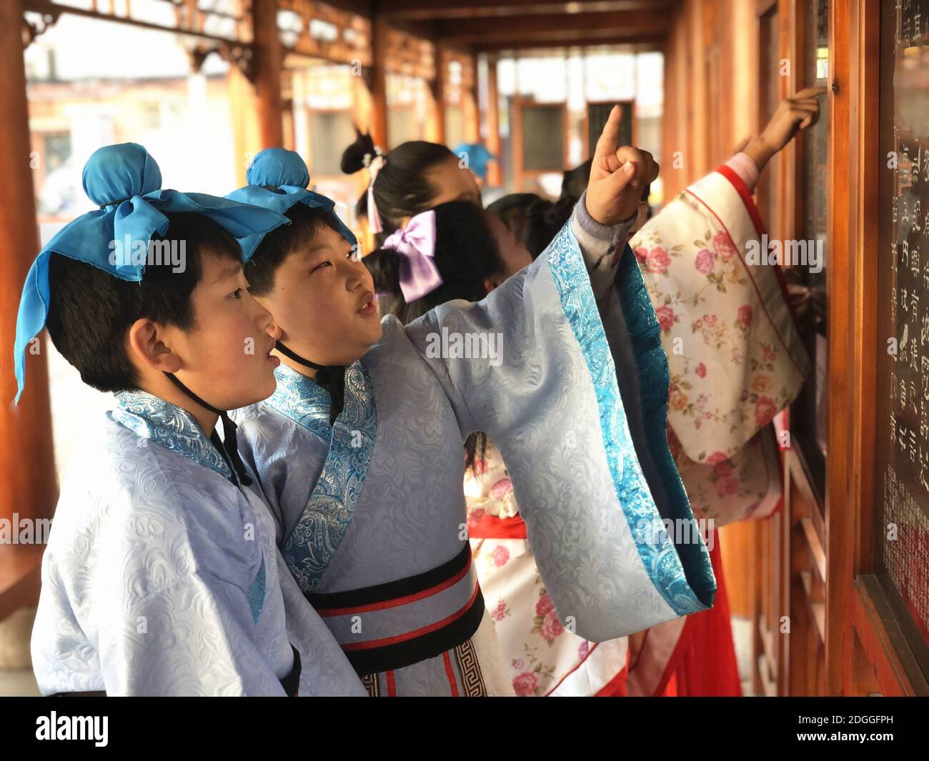 Les élèves de l'école primaire vêtus de Hanfu, un costume traditionnel chinois, écrivent la calligraphie et apprennent la culture traditionnelle dans la ville de Jilin, au nord-est Banque D'Images