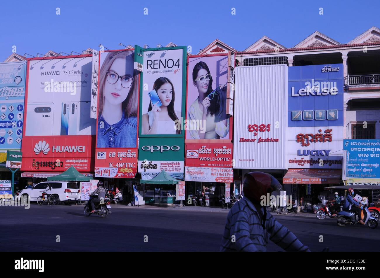 panneaux d'affichage géants pour les boutiques de smartphones et les boutiques d'optique avec trafic en dessous. Steung Meanchey, Phnom Penh, Cambodge. © Kraig Lieb Banque D'Images