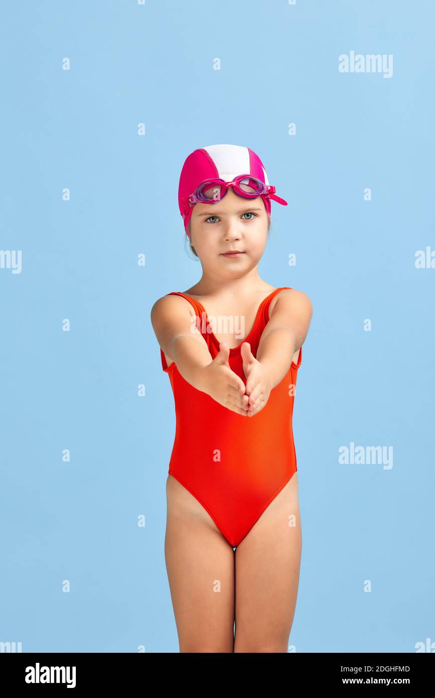 petite fille enfant en maillot de bain, lunettes de natation et bonnet de  bain sur fond bleu. enfant rêve de devenir un champion de natation Photo  Stock - Alamy