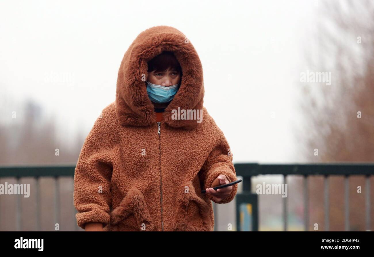 Les gens portent une veste épaisse en duvet marchant dans la rue, car la température descend en dessous du point de congélation dans la ville de Shenyang, province de Liaoning, au nord-est de la Chine, 1 Banque D'Images