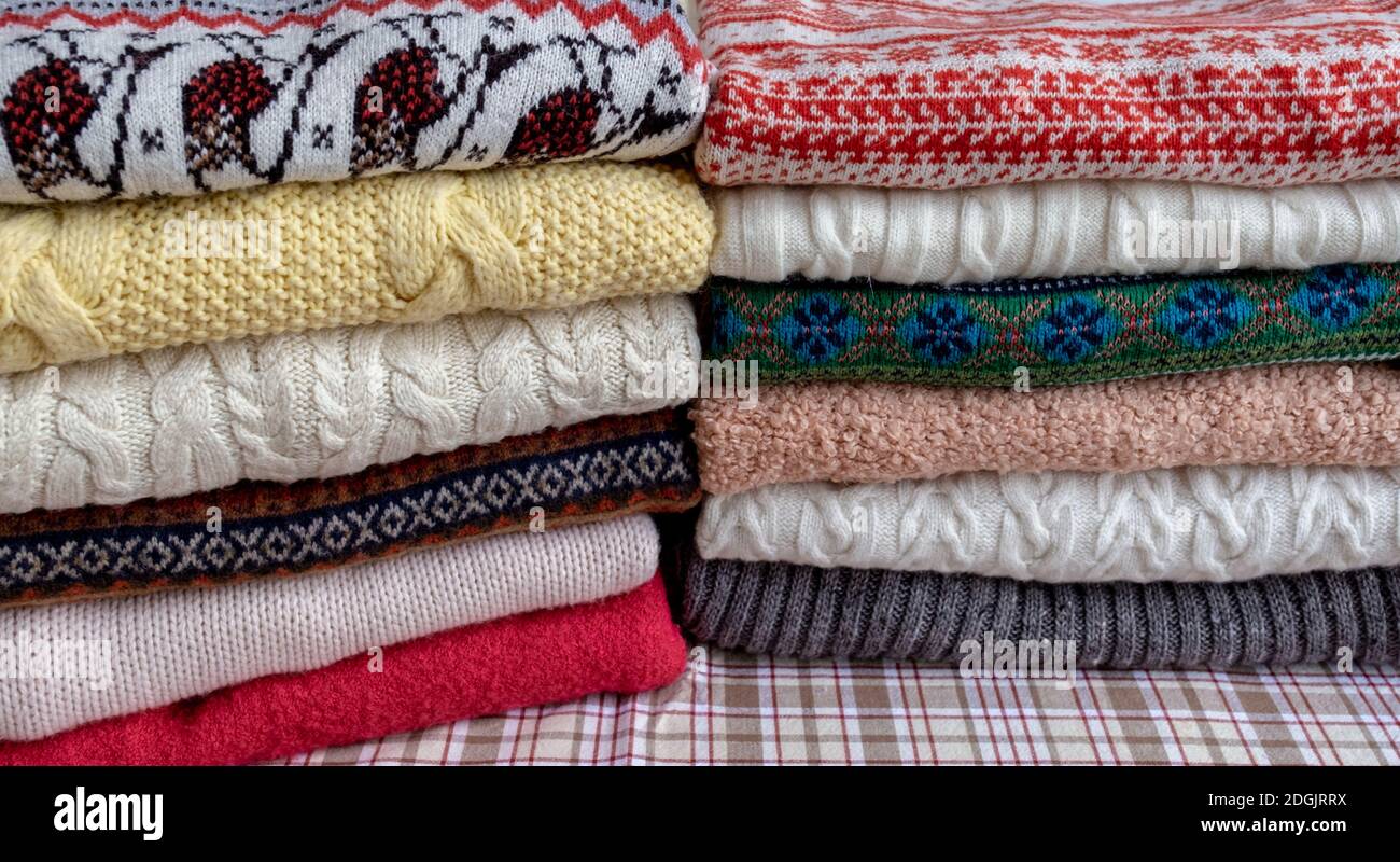Beaucoup de sweaters et pull-overs différentes couleurs pliées en deux  pieux sur la table Photo Stock - Alamy