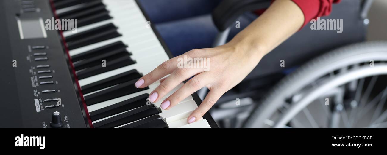 Une femme en fauteuil roulant appuie sur les touches du piano en gros plan  Photo Stock - Alamy