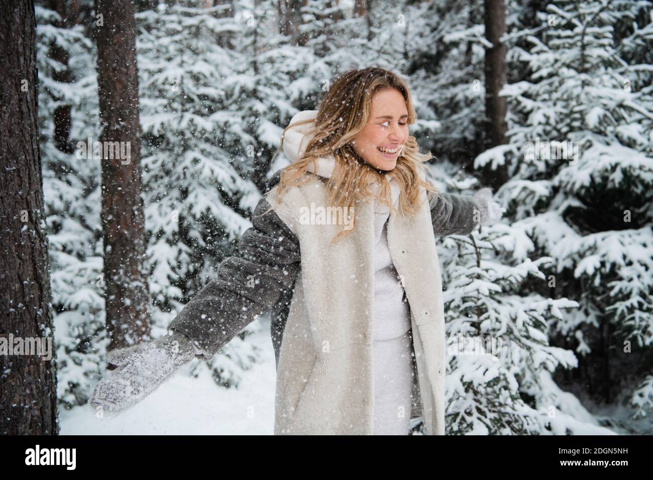 Belles promenades blondes dans le parc en hiver, la neige est partout. Banque D'Images
