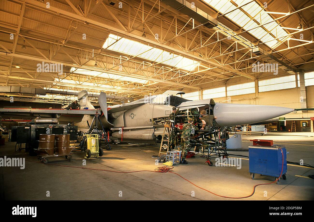 Base aérienne de RAF Upper Heyford Oxfordshire Royaume-Uni 1990. Siège de la 20e aile de chasseurs tactiques USAF. Techniciens d'équipage au sol travaillant sur F111 Aardvark dans un support de base. Banque D'Images