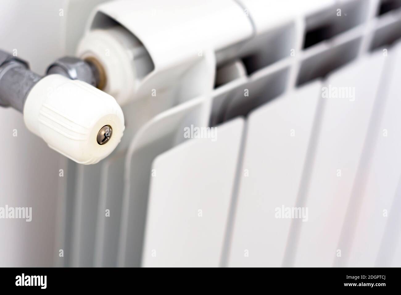 vue rapprochée du bouton blanc qui règle la température du radiateur. Chauffage et saison d'hiver Banque D'Images