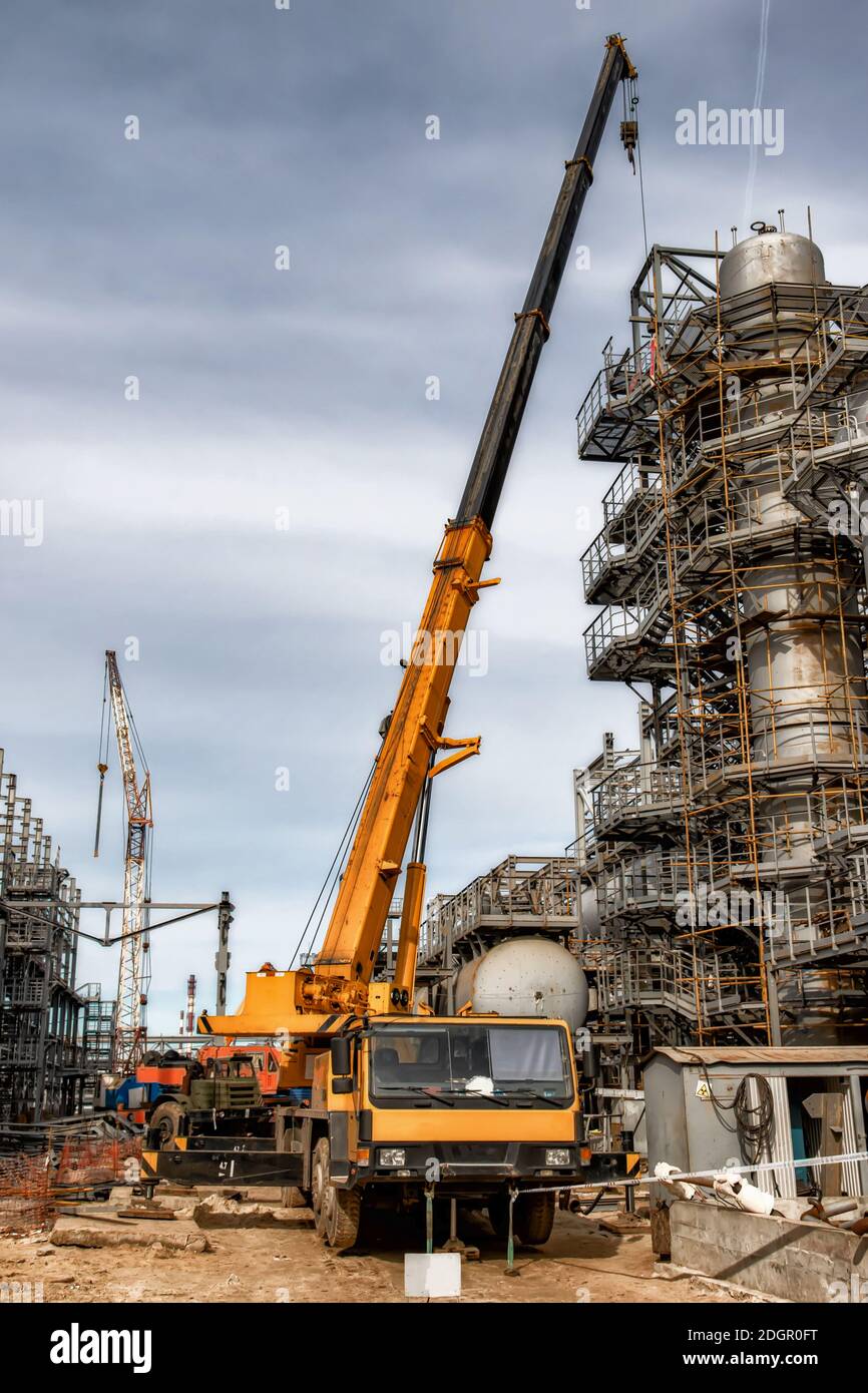 Une grande grue de voiture jaune se tient sur le chantier Banque D'Images