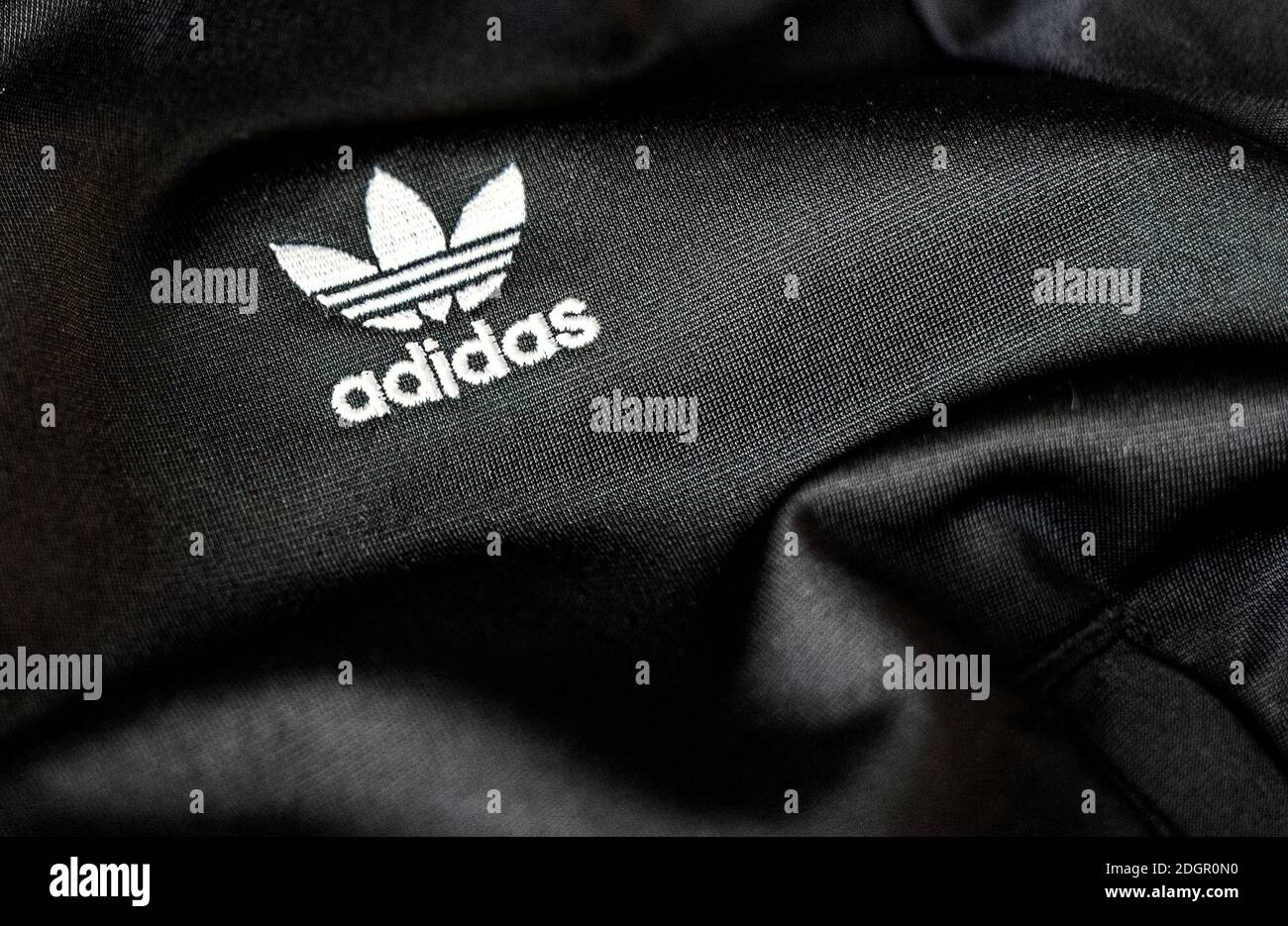 Rome, Italie, 15 novembre 2020 : le logo Adidas est cousu sur un tissu polyester noir recyclé. Vêtements de sport et logo emblématique. Célèbre marque allemande de vêtements de sport Banque D'Images
