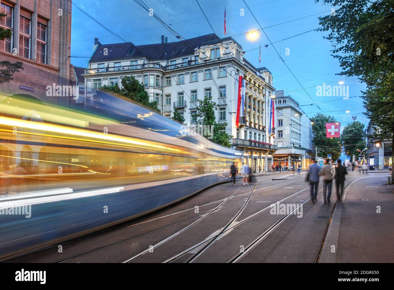Scène nocturne le long de la célèbre Bahnhofstrasse, Zurich, Suisse avec le majestueux Savoy Hotel Baur en ville en arrière-plan. Banque D'Images