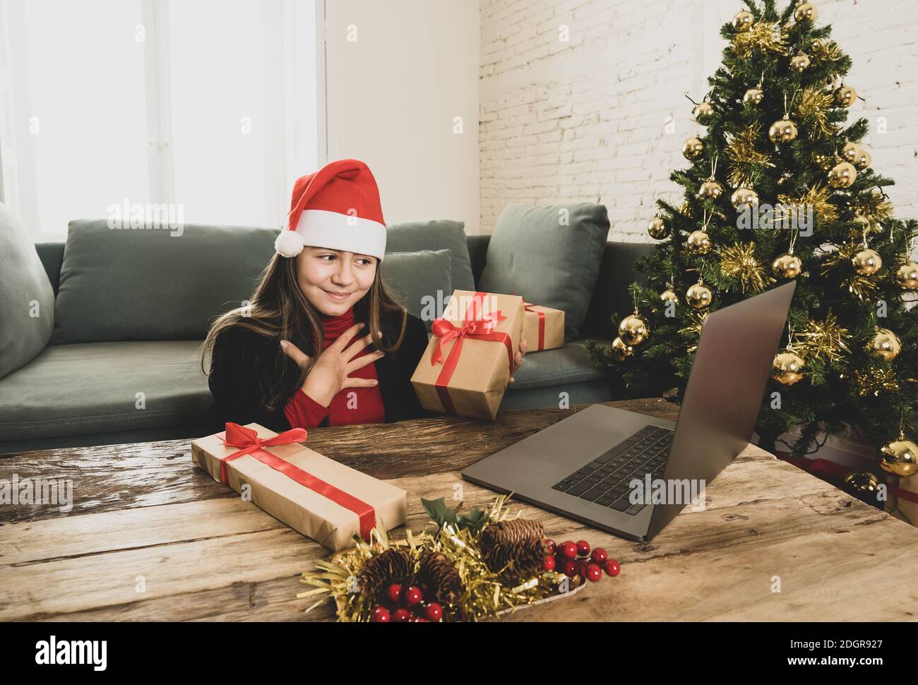 Deux beaux enfants heureux avec ordinateur vidéo d'appel de famille et de montrer des cadeaux de noël en ligne. Fête des fêtes virtuelles en raison de la COVID-19 qu Banque D'Images