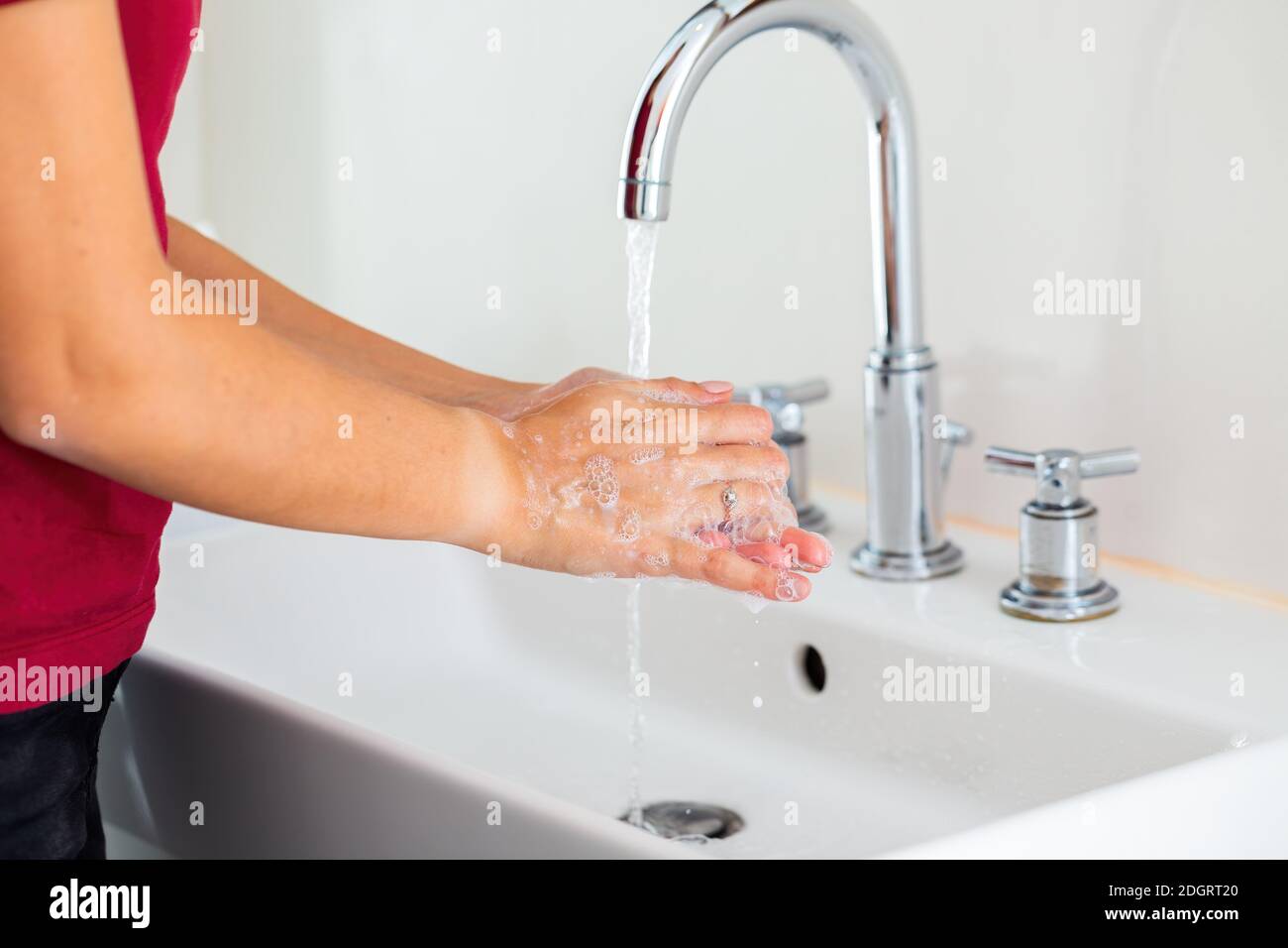 Les femmes se nettoyantes les mains avec de la mousse sous l'eau courante Banque D'Images