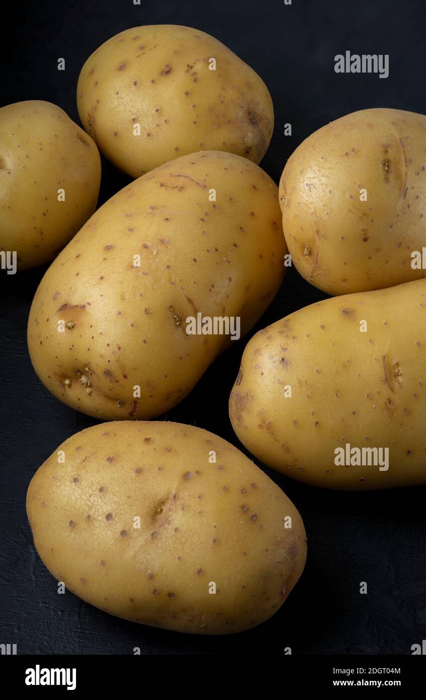 Beaucoup de pommes de terre sur un fond noir image empilée nourriture sombre photographie Banque D'Images