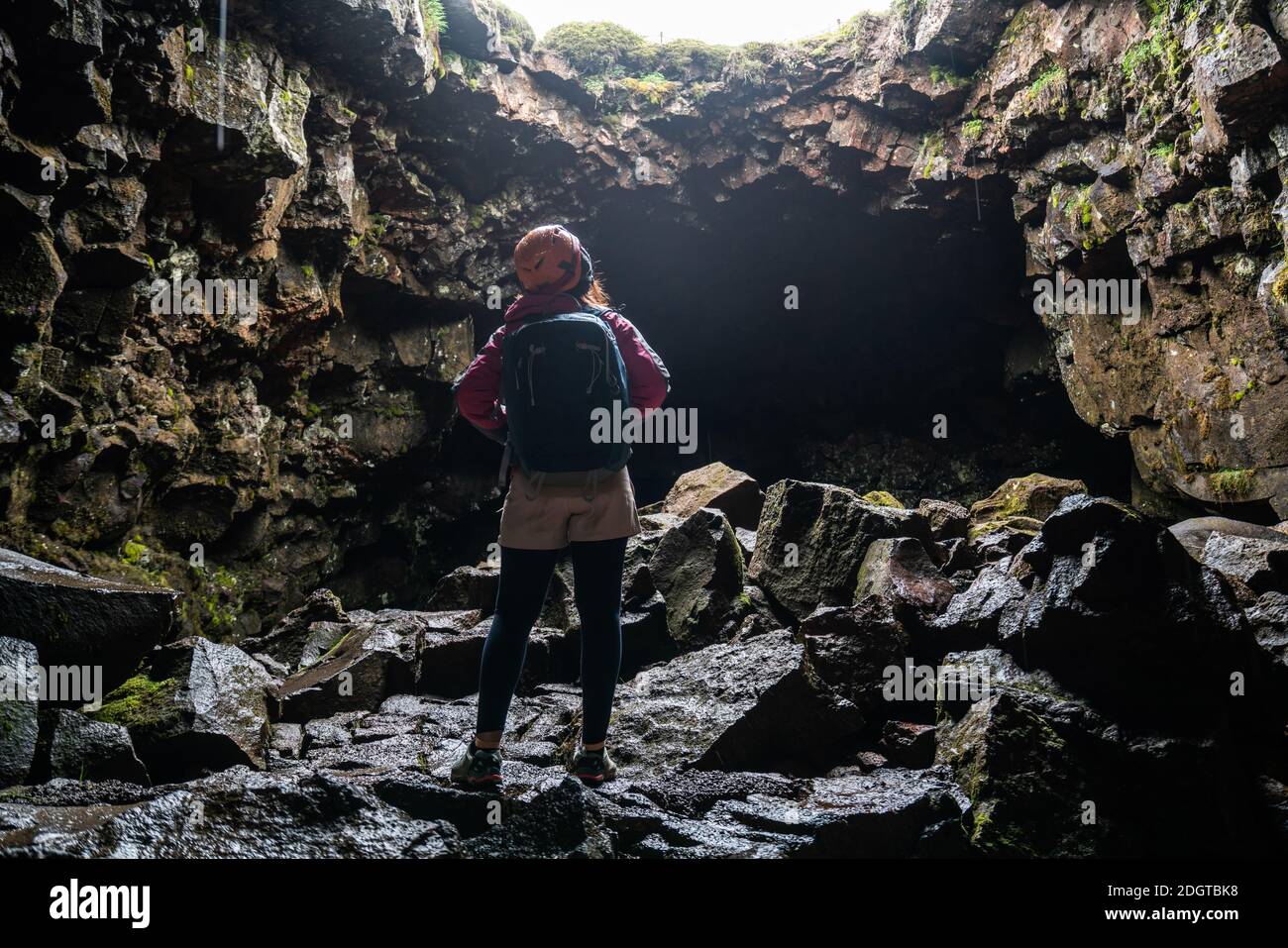 Une femme voyageur explore le tunnel de lave en Islande. Raufarholshellir est un beau monde caché de caverne. C'est l'une des plus longues et des plus connues lave Banque D'Images