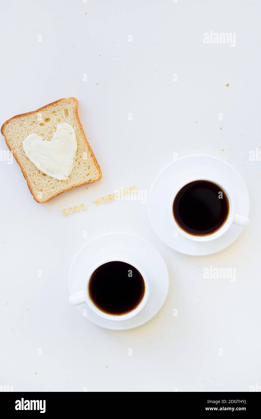 sandwich pour le petit déjeuner sous forme de coeur avec fromage - bon signe du matin et deux tasses de café Banque D'Images