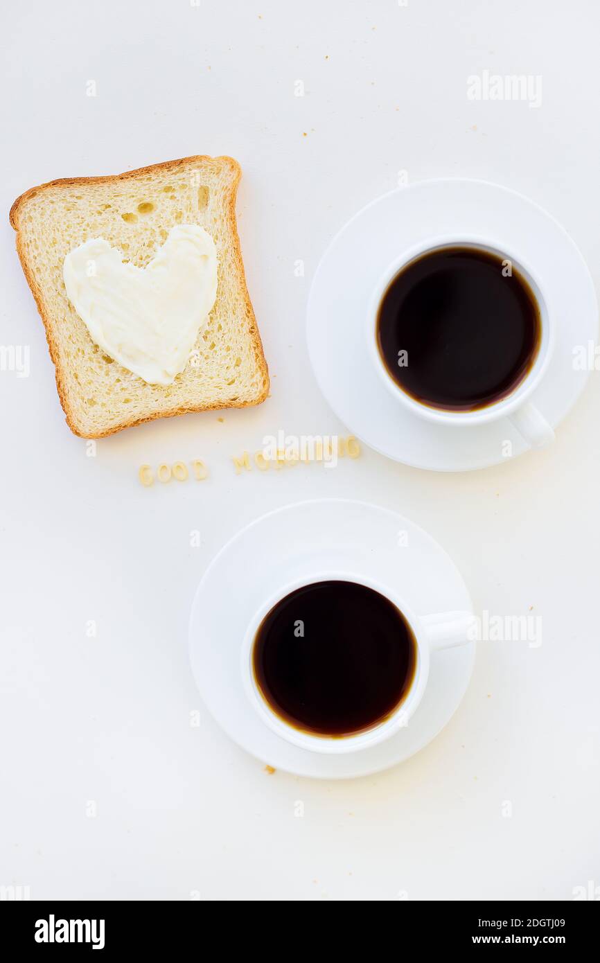 sandwich pour le petit déjeuner sous forme de coeur avec fromage - bon signe du matin et deux tasses de café Banque D'Images