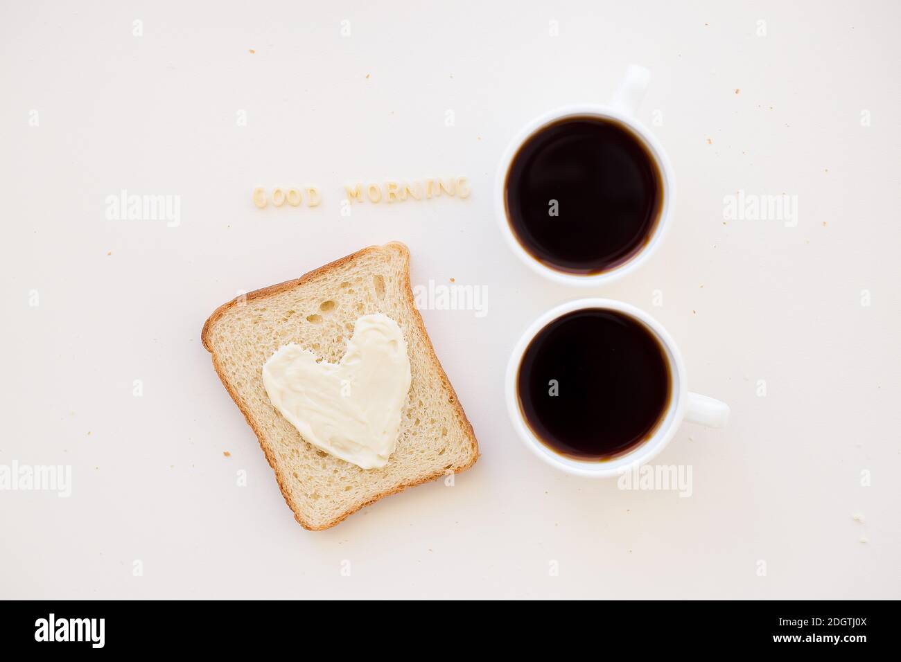 sandwich pour le petit déjeuner sous forme de coeur avec fromage - bon signe du matin et deux tasses de café Banque D'Images