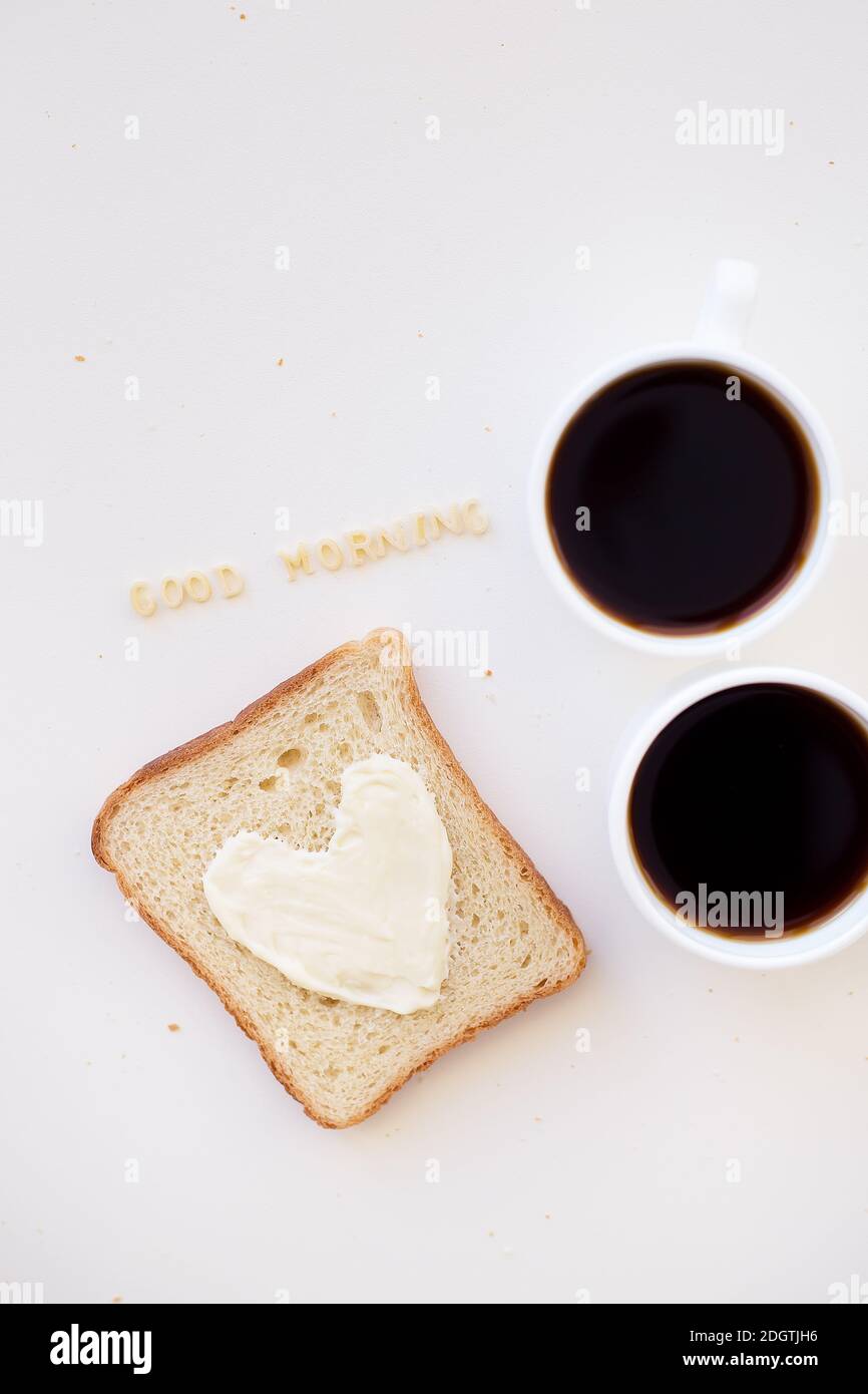 sandwich pour le petit déjeuner sous forme de coeur avec fromage - bon signe du matin et deux tasses de café Banque D'Images