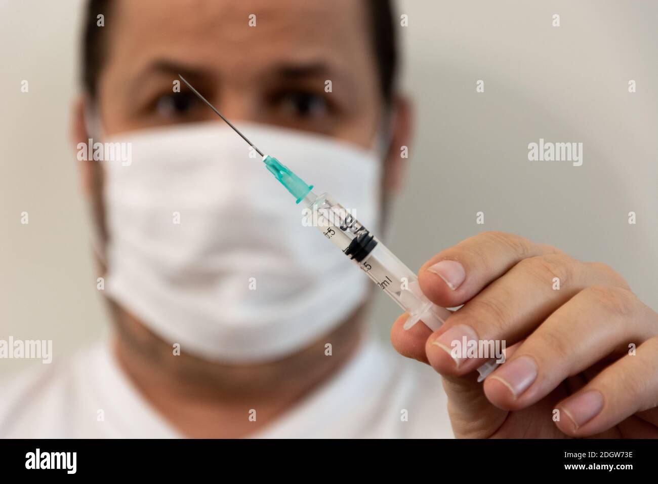 Un homme avec une seringue se prépare à l'injection, tenant une seringue en  plastique avec une aiguille Photo Stock - Alamy