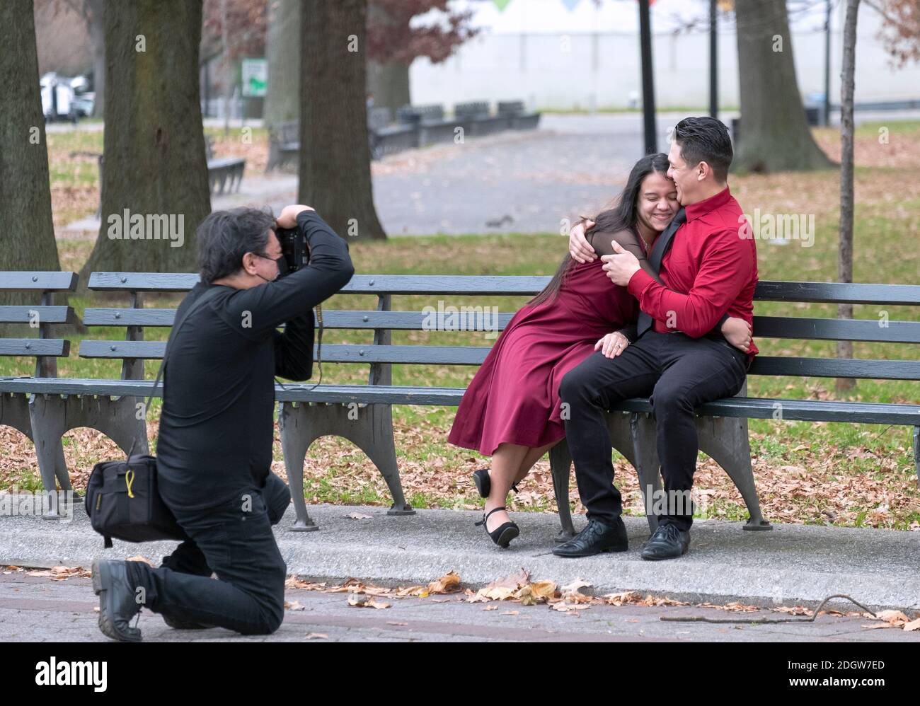 Un jeune couple se fait un rire lors d'une séance de photo, peut-être pour célébrer leur engagement. À Flushing Meadows Park, Queens, New York. Banque D'Images
