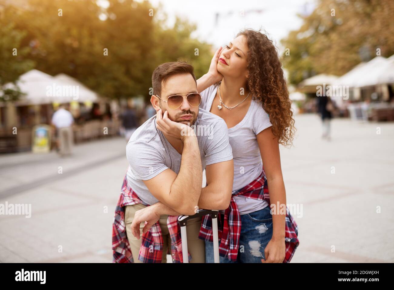 Jeune usé le couple mignon est penché contre leur sac en attendant leur transport pour arriver. Banque D'Images
