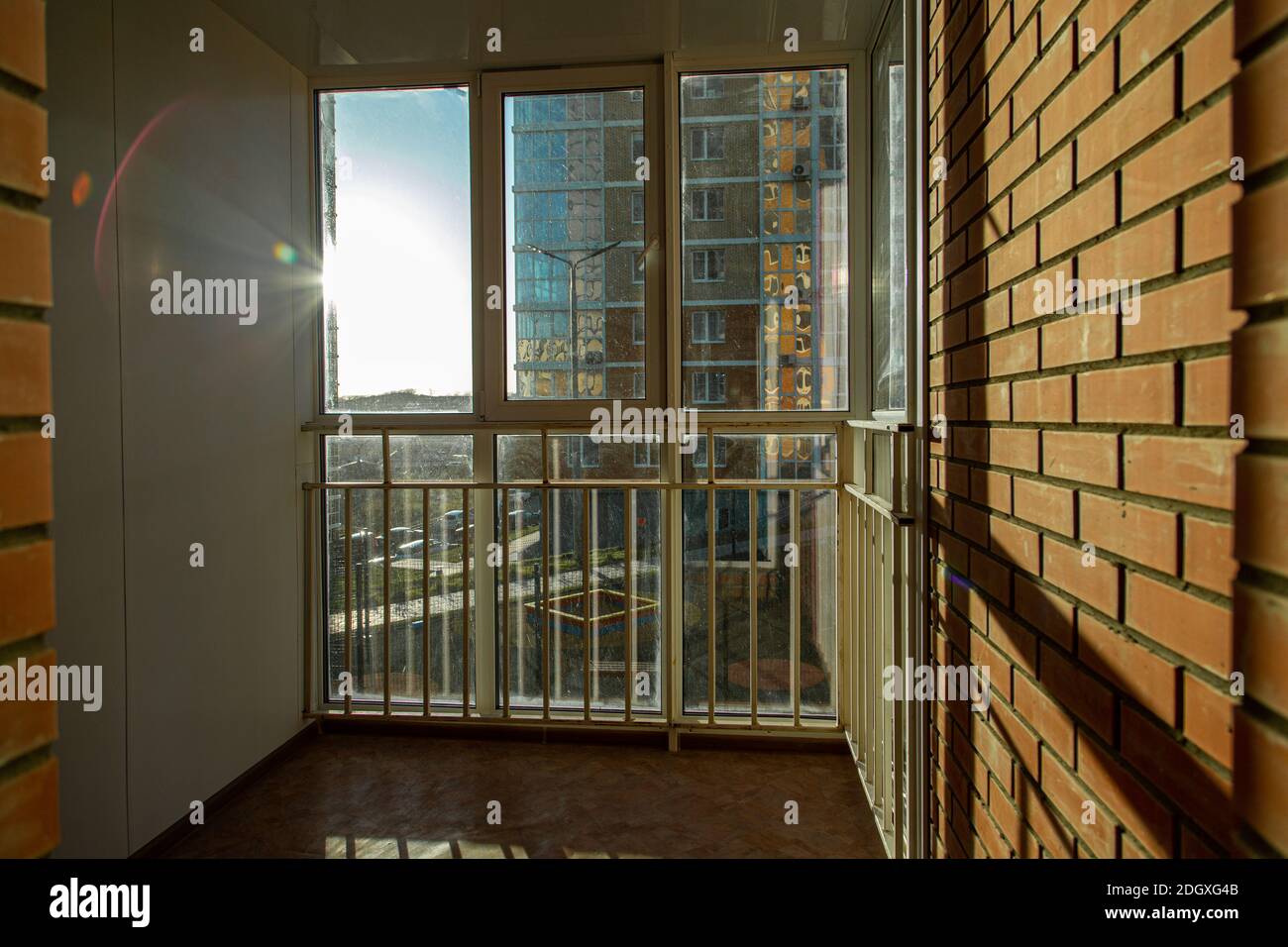 Le soleil brillant brille magnifiquement par la fenêtre sur le balcon avec  des bars et des fenêtres en plastique. Projeter une ombre sur un mur de  briques Photo Stock - Alamy
