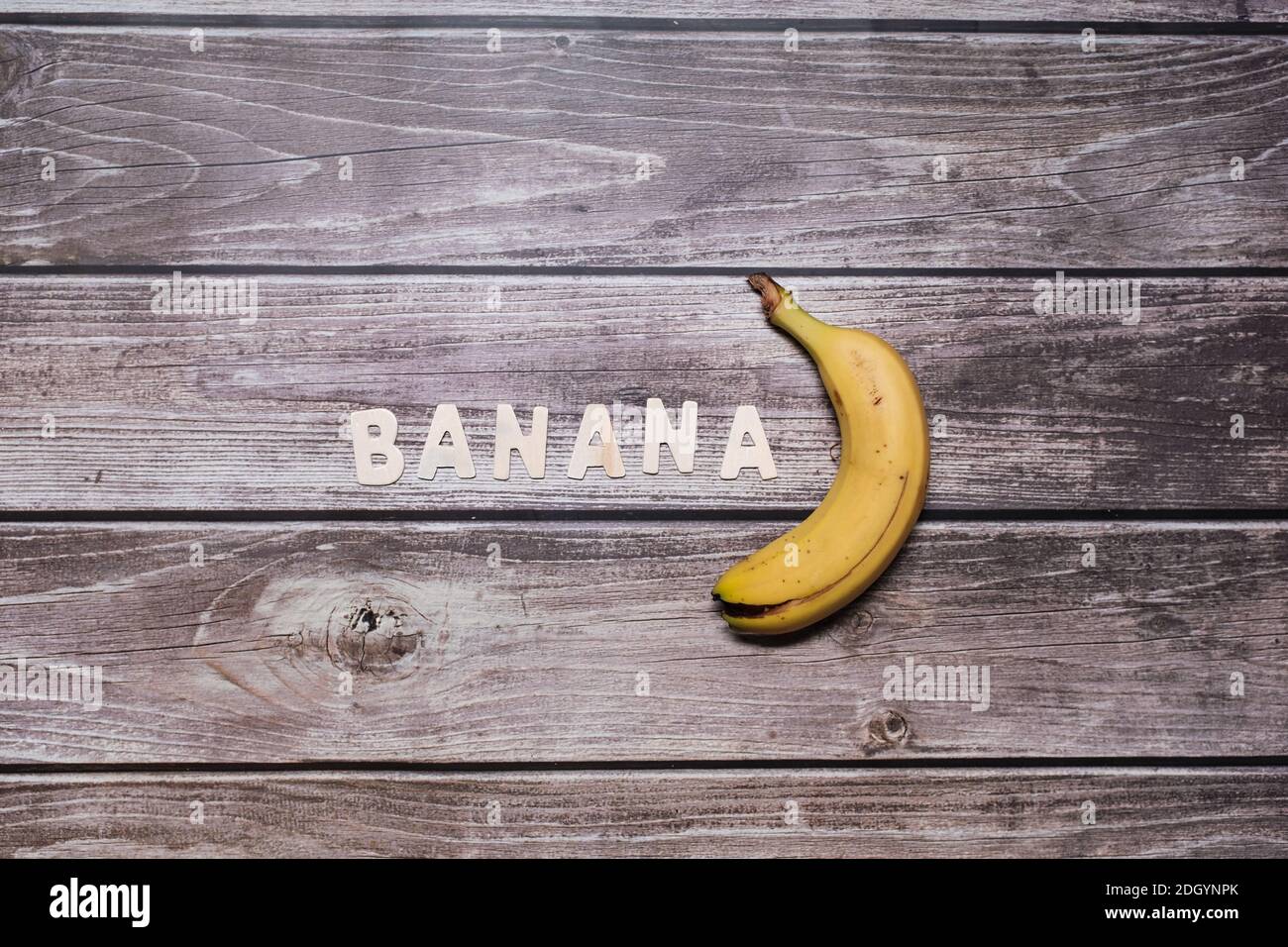 Banane jaune avec lettres en bois Banque D'Images