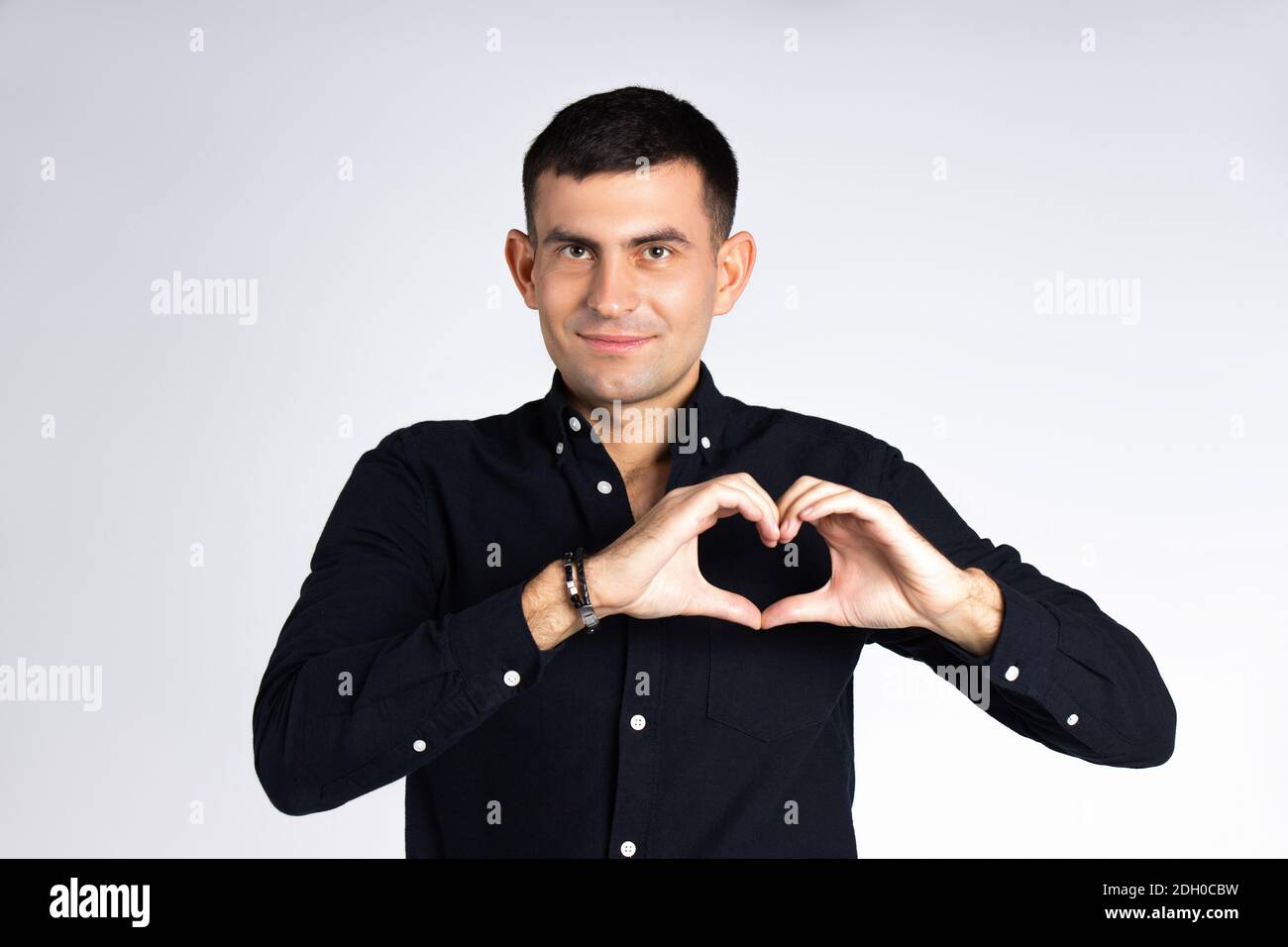 Un homme tient un coeur de ses mains sur un fond blanc. Concept de don, de charité et de Saint-Valentin. Banque D'Images
