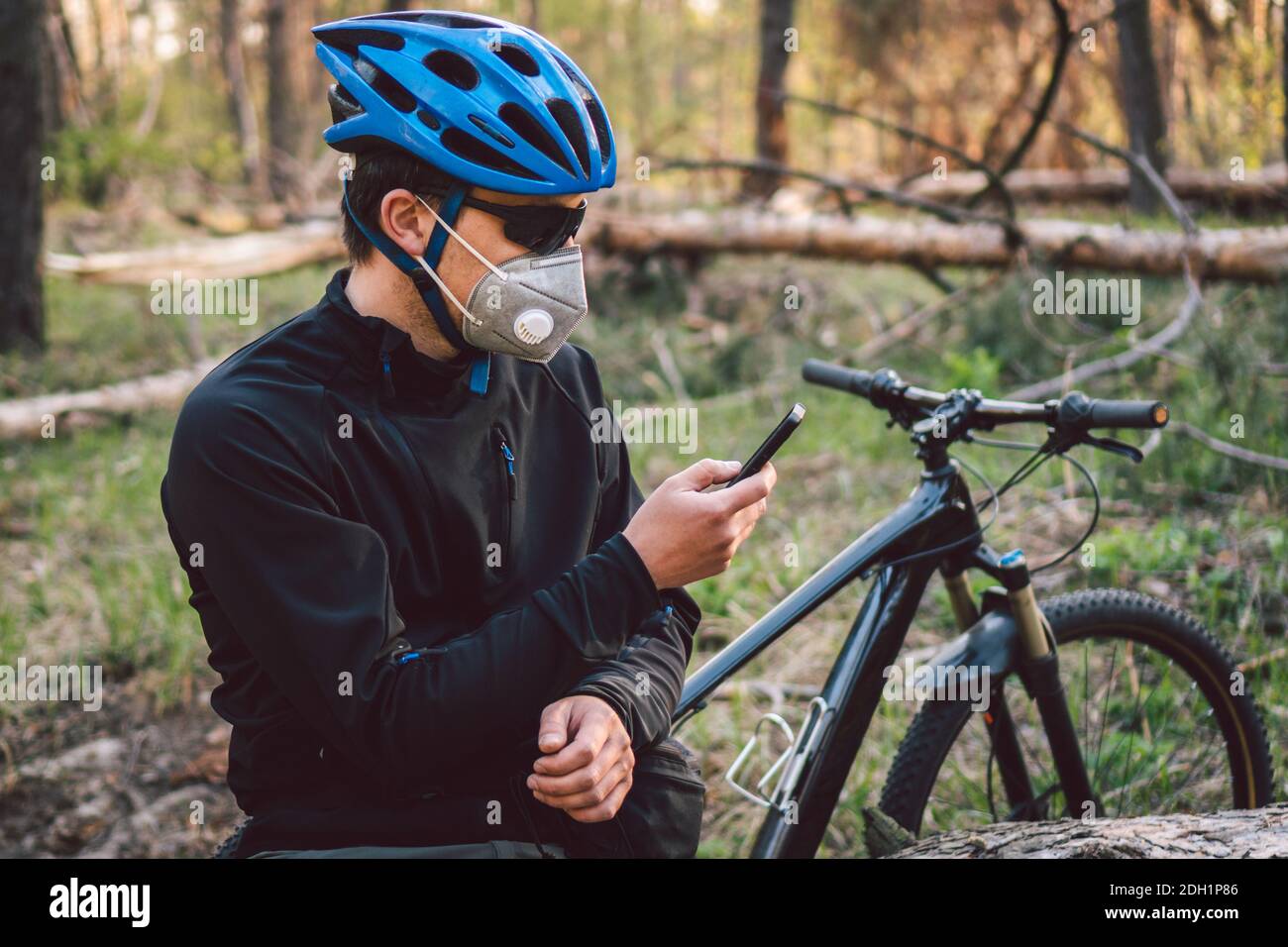 Cycliste masculin portant un masque facial, avec filtre pm 2.5. Coronavirus ou Covid thème 19. Athlète en masque de protection avec vélo Banque D'Images
