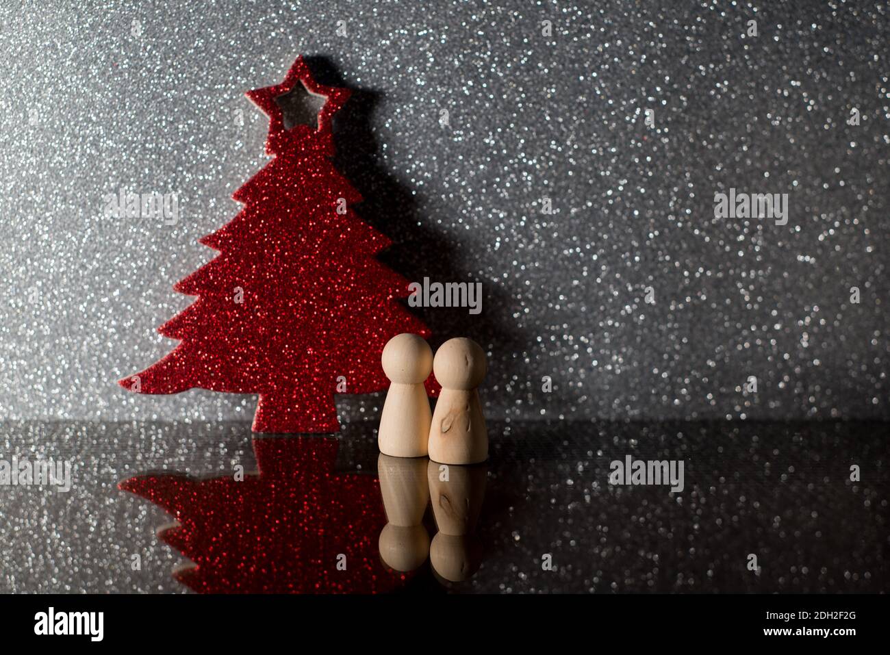 Deux pions devant un arbre de Noël rouge. noël seul. Solitude à noël. Représentation de noël 2020 Banque D'Images