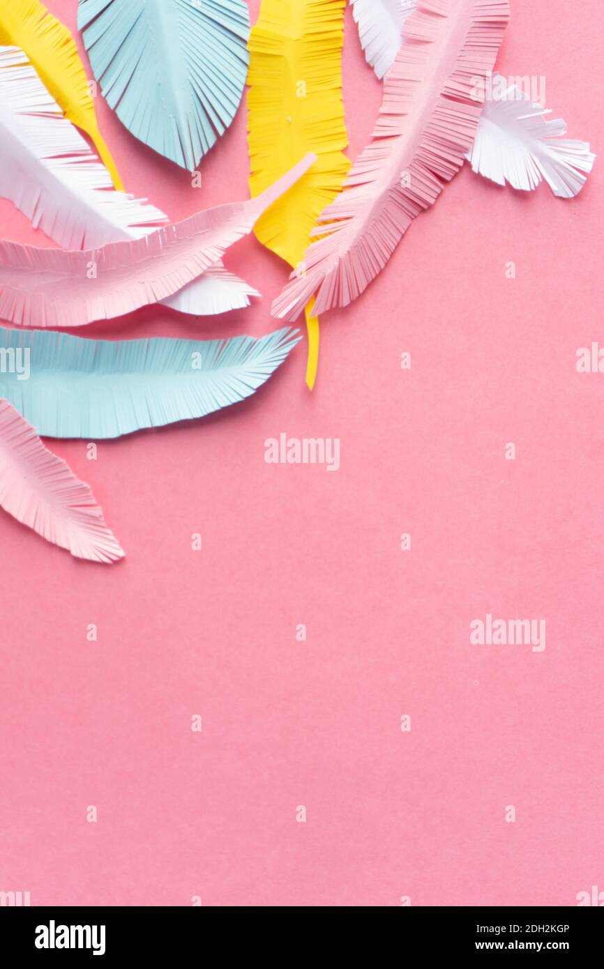 plumes de papier colorées sur fond rose avec espace de copie, composition verticale Banque D'Images