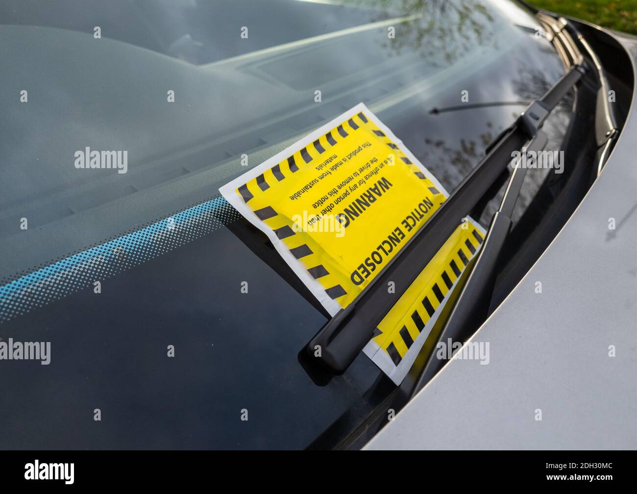 Un billet de stationnement ou un avis de pénalité attaché au pare-brise d'une voiture Banque D'Images