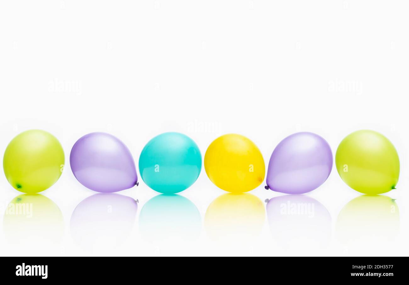 Des ballons colorés disposés en rangée créent une atmosphère festive pour les célébrations ou les fêtes Banque D'Images