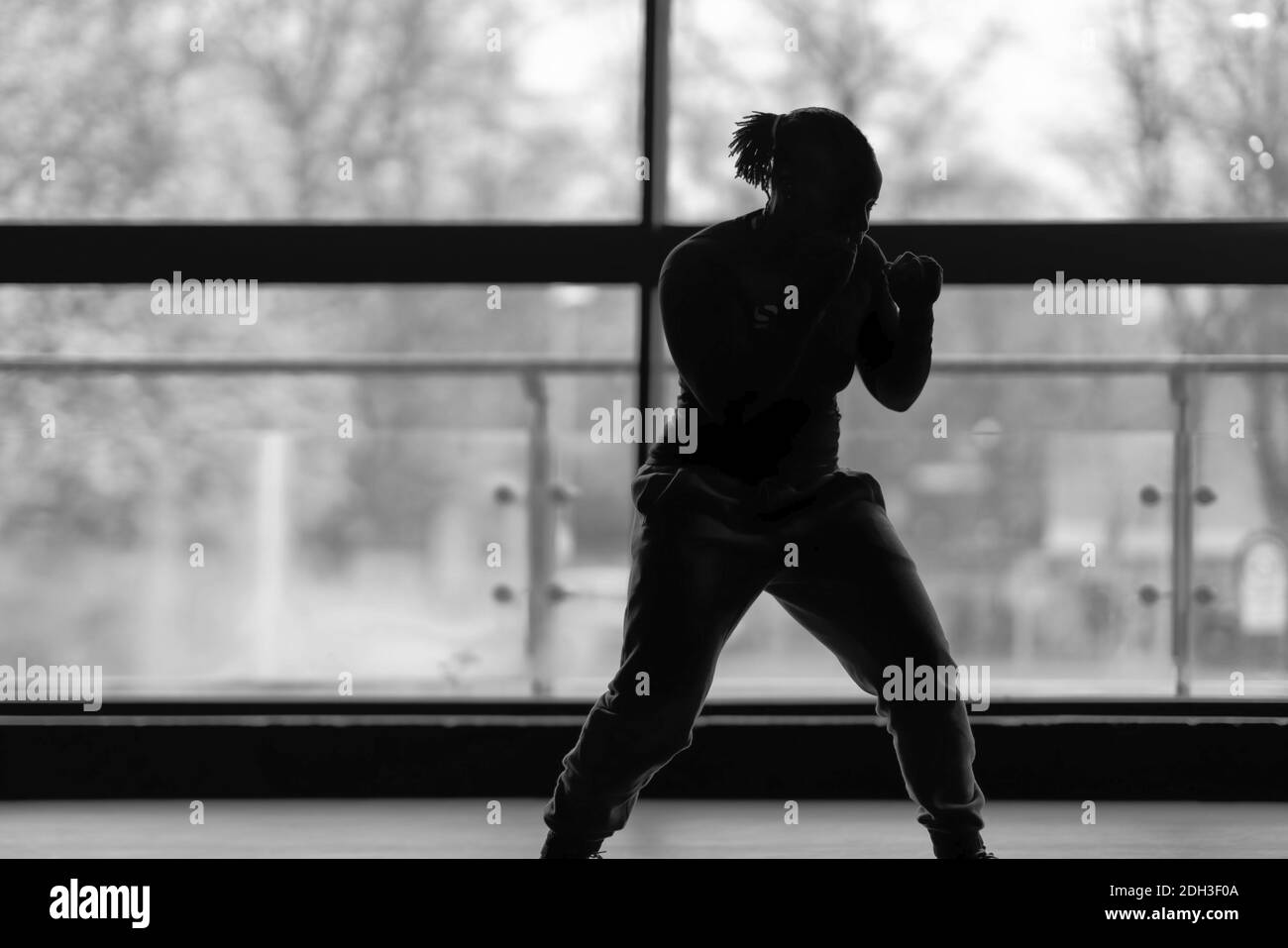 Femme s'entraîner à la boxe à la salle de gym, photo en noir et blanc Banque D'Images