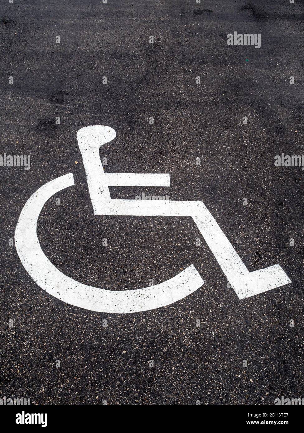 Ist Ein Rollstuhl auf einem Parkplatz für behinderte angebracht. Banque D'Images