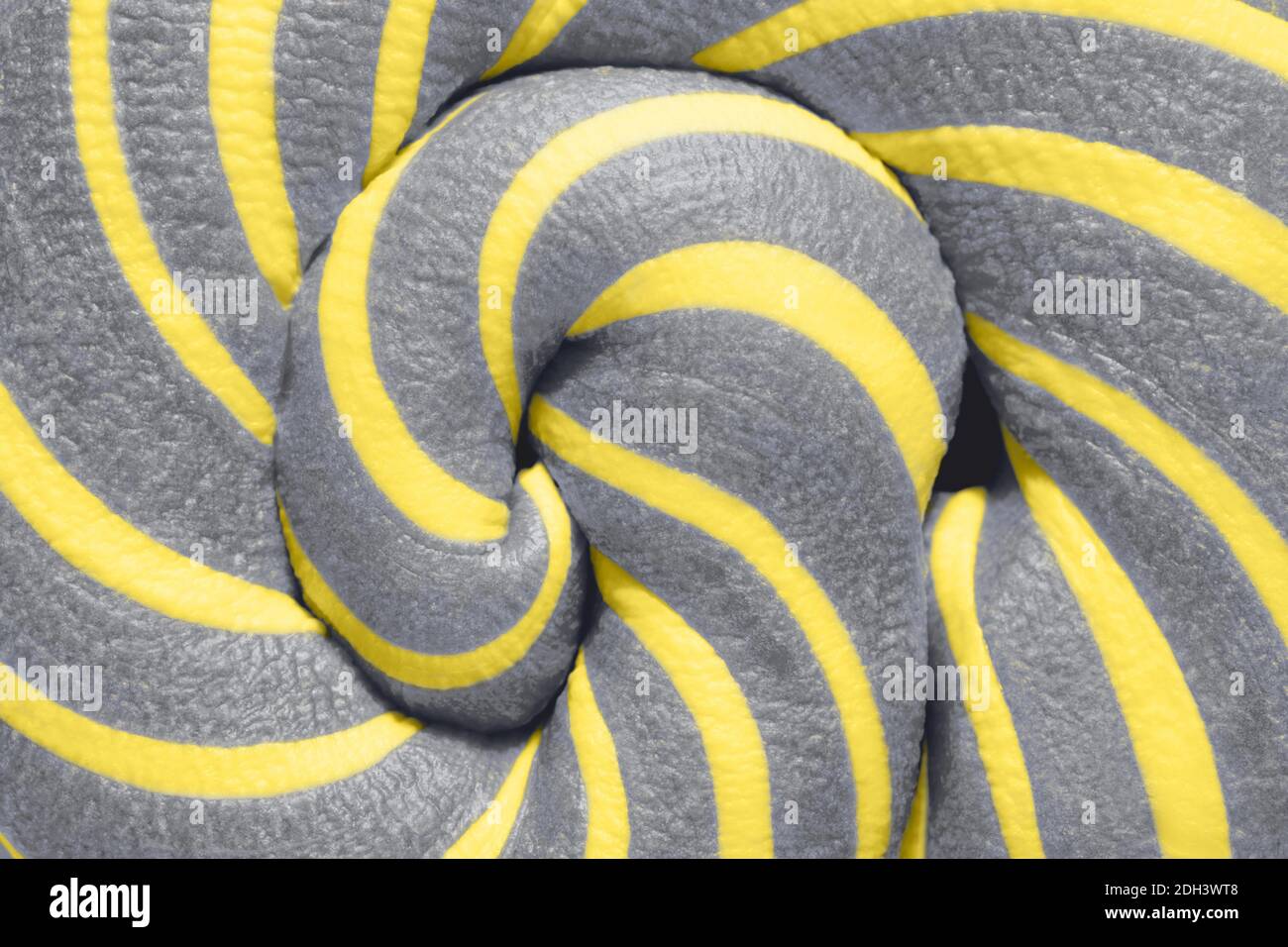 Fond abstrait de bonbon de Lollipop gris et jaune illuminé par la tourbillette. Gros plan. Couleur de l'année 2021. Banque D'Images