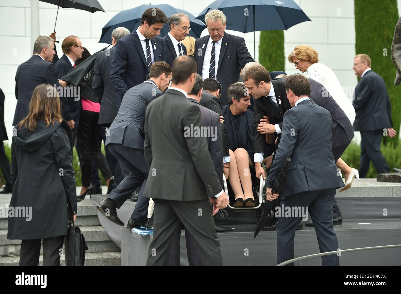 Le président français Emmanuel Macron assiste le président du Comité paralympique français Emmanuelle Assmann en tant qu'épouse du président français Brigitte Macron et le président du Comité International Olympique (CIO), Thomas Bach, de l'Allemagne, en tête d'une photographie de groupe à Lausanne le 10 juillet 2017, lors d'un événement du Comité International Olympique (CIO). Les membres du Comité International Olympique (CIO) tiendront une session extraordinaire après des présentations des équipes de campagne pour Los Angeles et Paris, luttant pour le droit de succéder à 2020 hôtes à Tokyo et de monter les Jeux dans sept ans. Photo b Banque D'Images