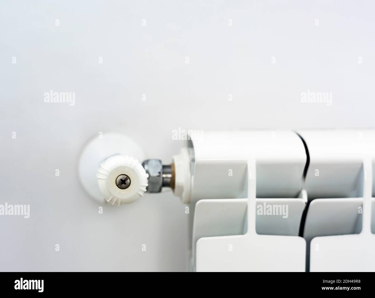 vue rapprochée du bouton blanc qui règle la température du radiateur. Chauffage et saison d'hiver Banque D'Images