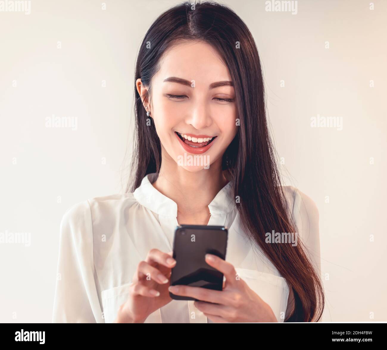 Portrait d'une femme d'affaires heureuse utilisant un téléphone portable Banque D'Images