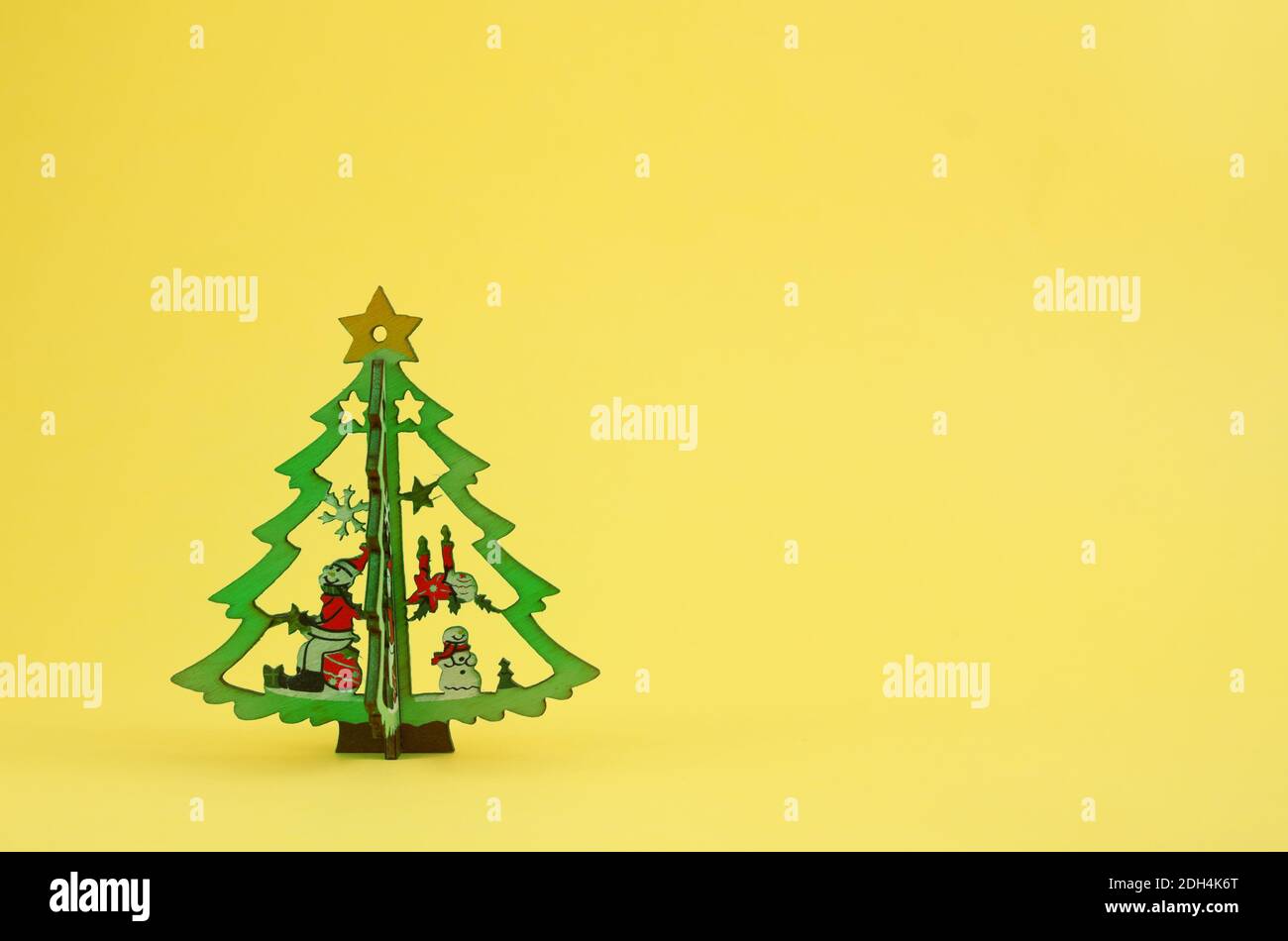 Fond de Noël jaune minimaliste avec sapin de Noël en bois avec espace pour le texte. Banque D'Images